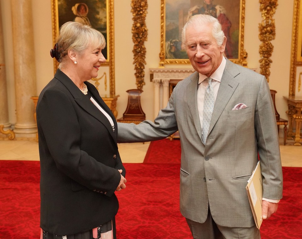 Charles greets Dame Martina Milburn before an audience in the Billiard Room at Buckingham Palace