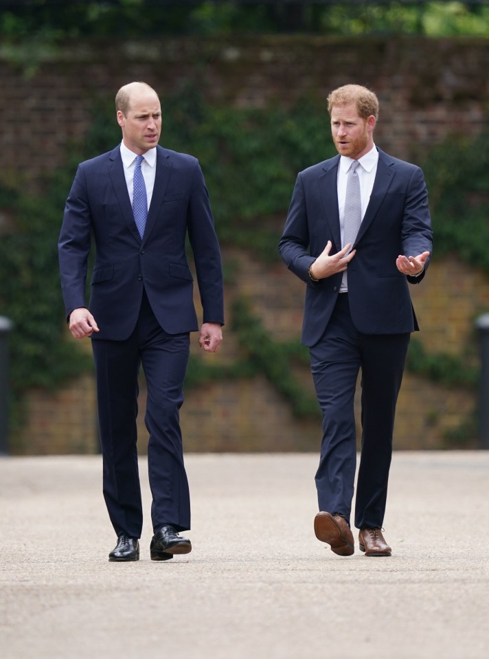 a man in a suit talks to another man in a suit