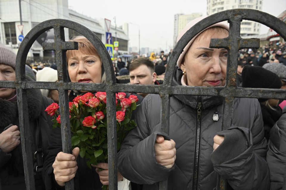 Mourners are separated from the church by iron fences