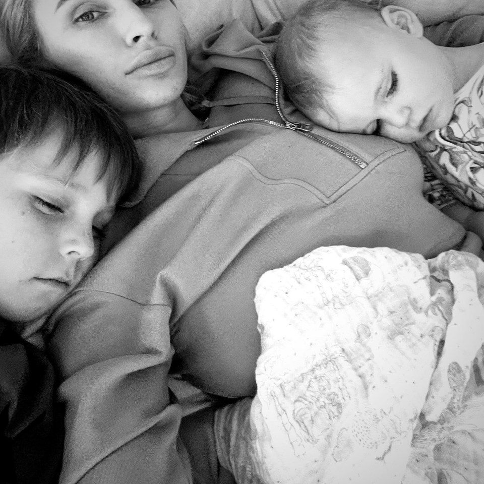 a black and white photo of a woman and two children