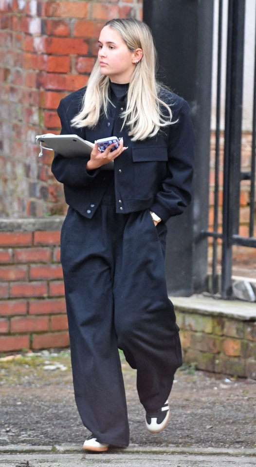 Molly wore a completely black ensemble, with black tracksuit bottoms, a black top, and a fitted cropped blazer-style coat.