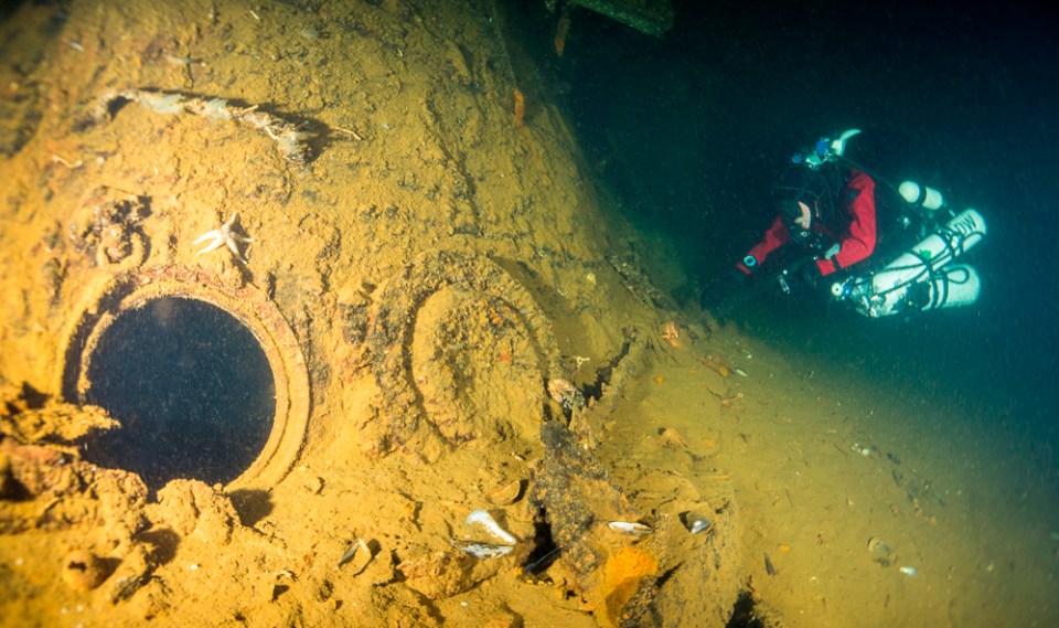 A person dives near the porthole on the SMS Konig