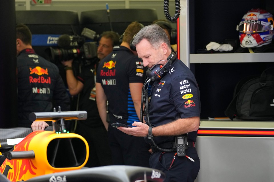 Christian Horner looking at his mobile phone in the team garage