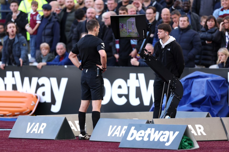 Ref Jarred Gillett looks at a monitor as he watches a VAR Review of Jarrod Bowen's goal