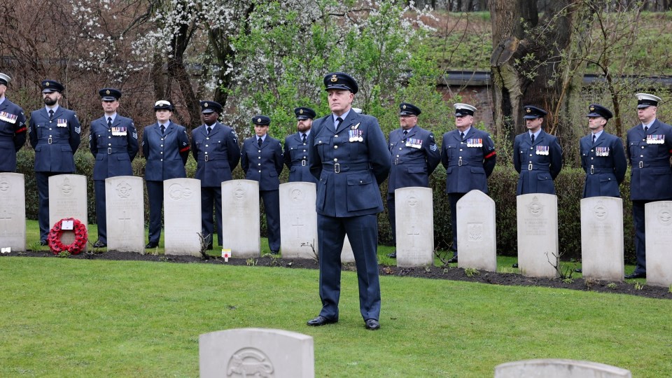 RAF personnel stand behind the graves of those lost in the atrocity committed by the Gestapo following the Great Escape