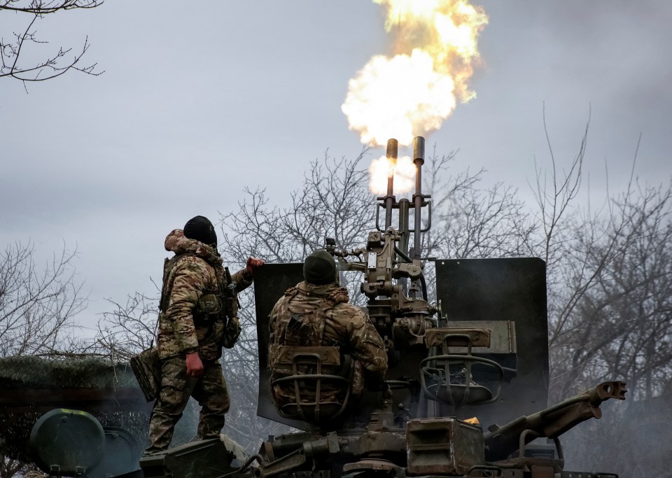 Ukrainian troops fire a cannon at the frontline near Bakhmut