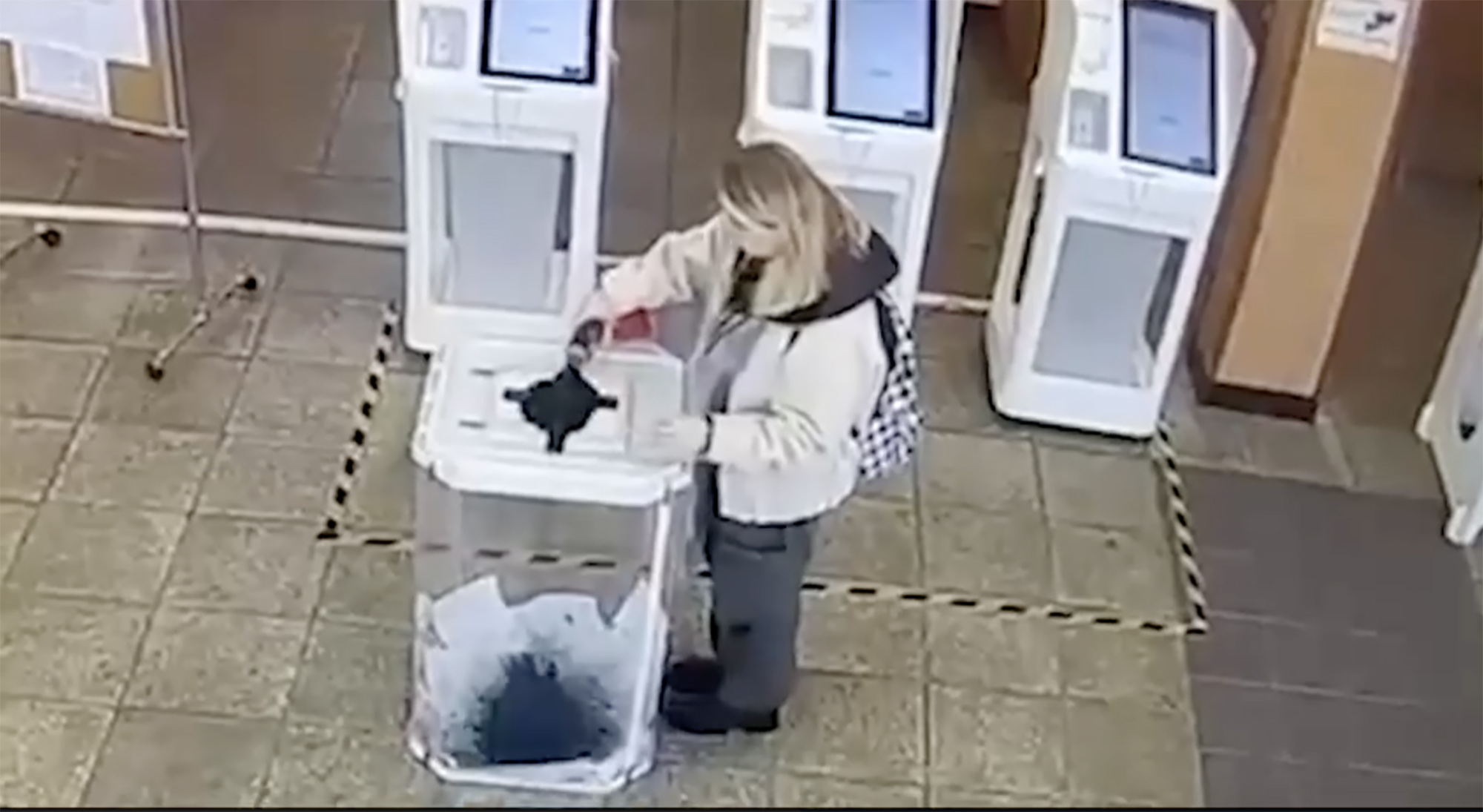 50 Russians were arrested today after protesting, pictured: one woman ruins ballots with ink