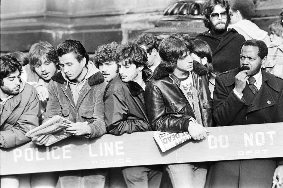 Fans of John Lennon gather outside The Dakota apartment building in Manhattan, New York after he was murdered