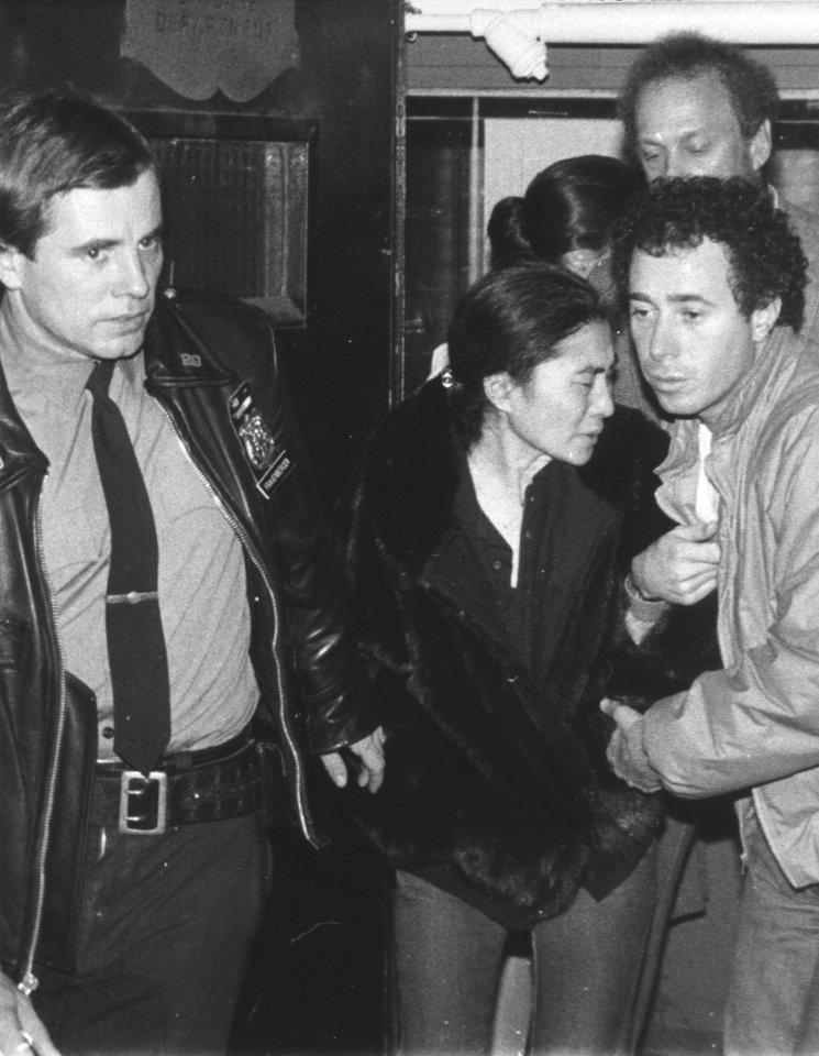 Yoko Ono, centre, is aided by a policeman and David Geffen, right, of Geffen Records as she leaves Roosevelt Hospital where her husband was pronounced dead