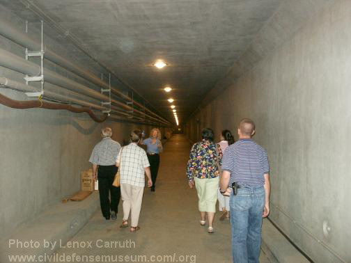 A group walks through through the West entrance tunnel into the facility