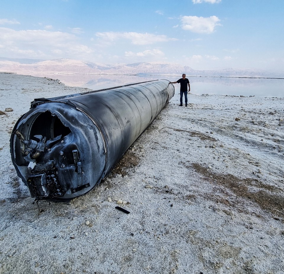 A downed Iranian ballistic missile lies on the shore of the Dead Sea