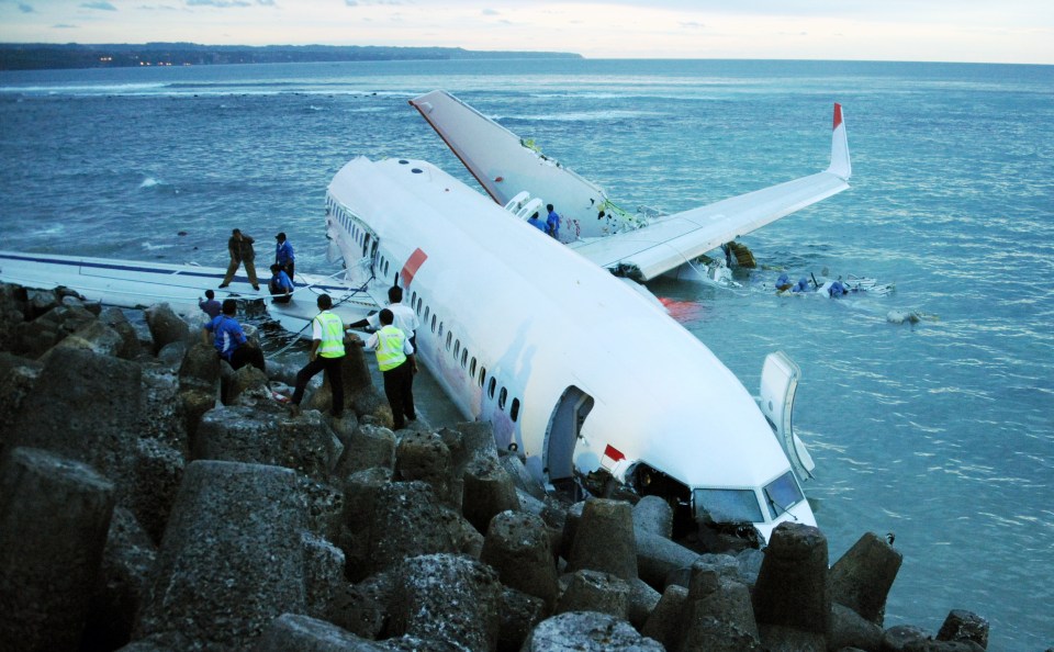 Indonesia rescuers inspect a Lion Air Boeing 737 before removing its fixtures as it lies partially submerged in the water three days after it crashed in 2013