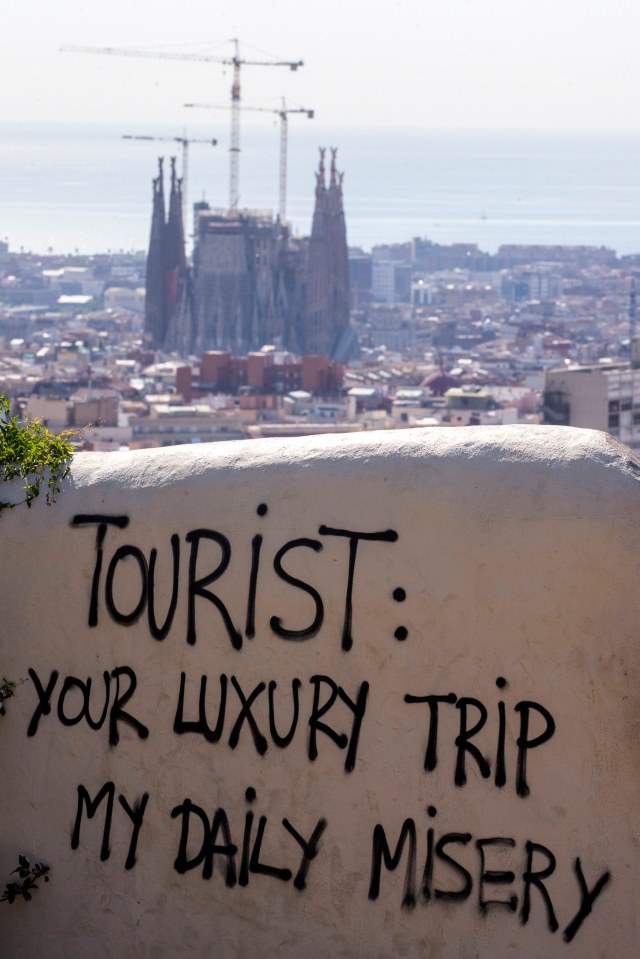 A graffiti against tourists is seen at the Guell Park in Barcelona, Spain