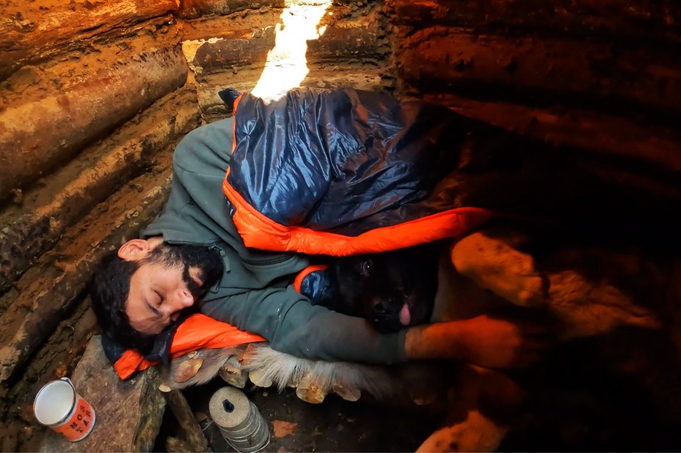 Hakan sleeping with his loyal dog, Sila, inside the hut he'd built