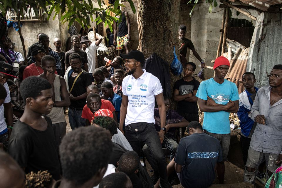 An anti-drug activist talks with drug users at a Kush drug den