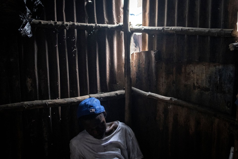 A man sleeps inside a drug den at the Kington landfill site in Freetown