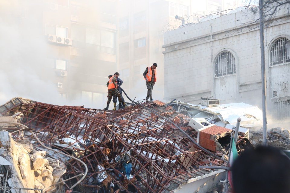 Rescue workers at the site of the airstrike in Damascus, Syria