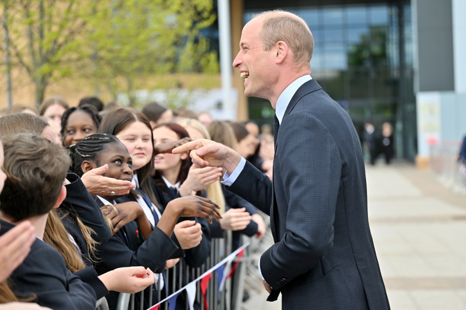 The prince was greeted by school children lining up to shake his hand