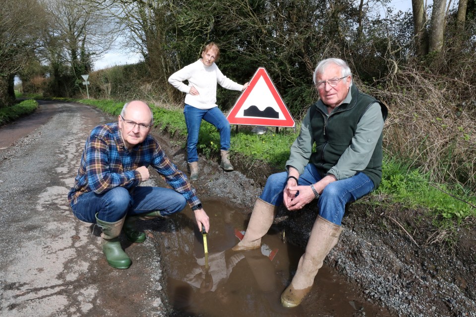 Kevin Harlock (left), Caroline Wilkie (center) and Ronnie Wilkie (right) with potholes on a country lane near their home