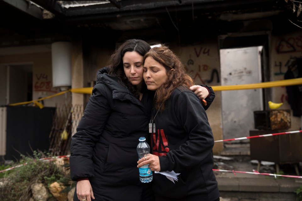 Amit Soussana (r) is consoled by a friend near her house in January