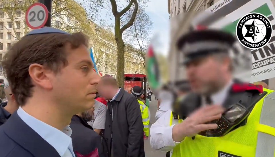 Gideon Falter speaking to a Met Police officer during a pro-Palestine march in London