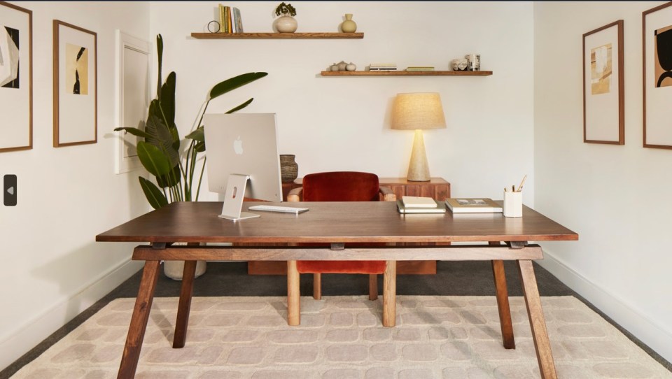 a wooden desk with an apple computer on it