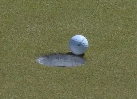 The golfer paused on the green as he waited for his ball to drop into the hole