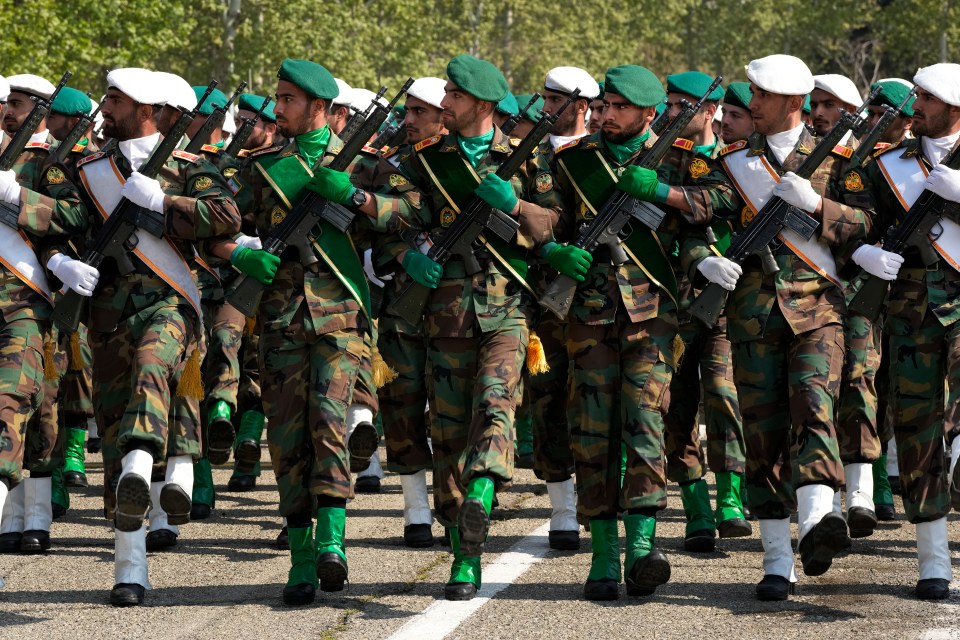 Gun-toting soldiers are wheeled out in distinctive Iranian army gear