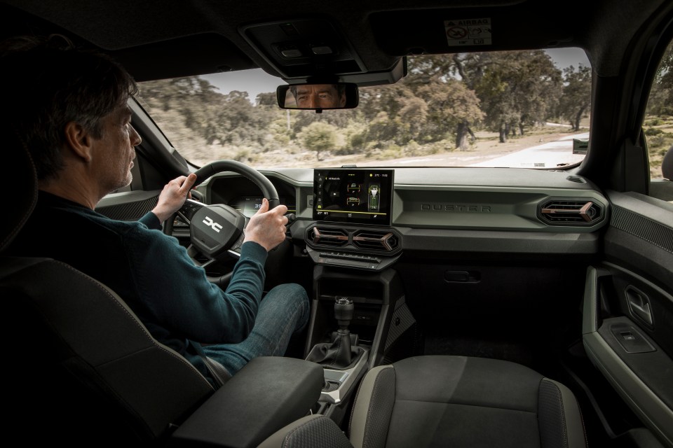 The slab-like dash has Duster stamped across it in big letters. Much like a Defender