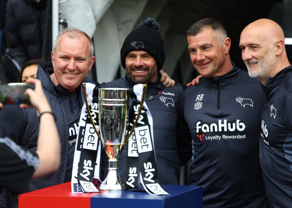 Warne still wears a hat despite the white-hot atmosphere as he celebrates promotion with his staff