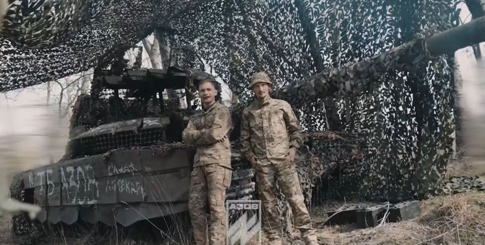 Ukrainian soldiers pose with the T-72B3M Russian tank they captured