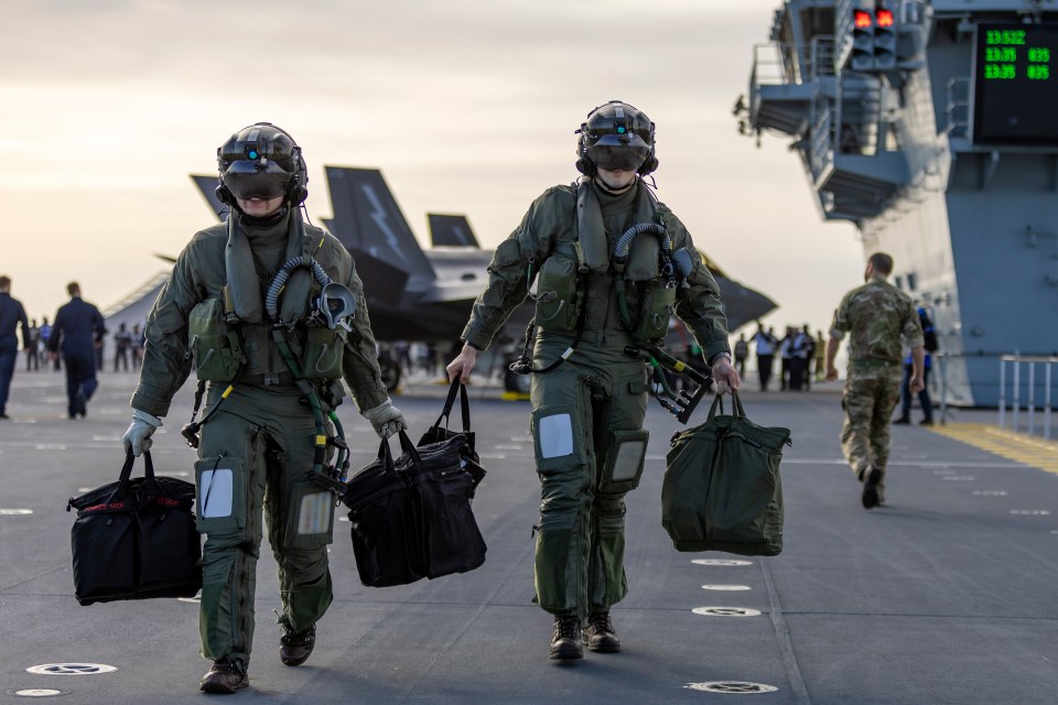 Pilots of F-35B Lightning jets on the flight deck of the Royal Navy aircraft carrier HMS Prince of Wales