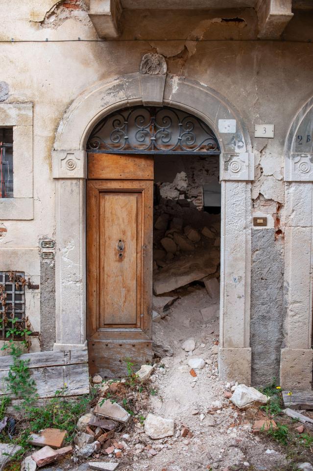 An open door reveals the destruction inside this building