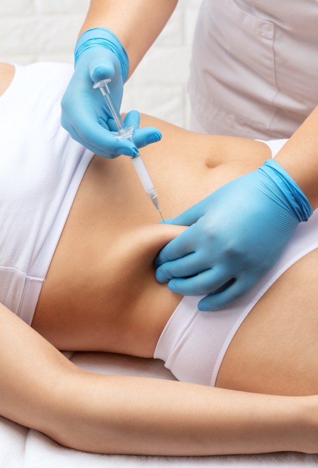 a woman is getting an injection in her stomach