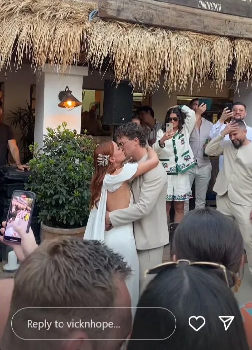 The newlyweds enjoyed a kiss in front of their guest