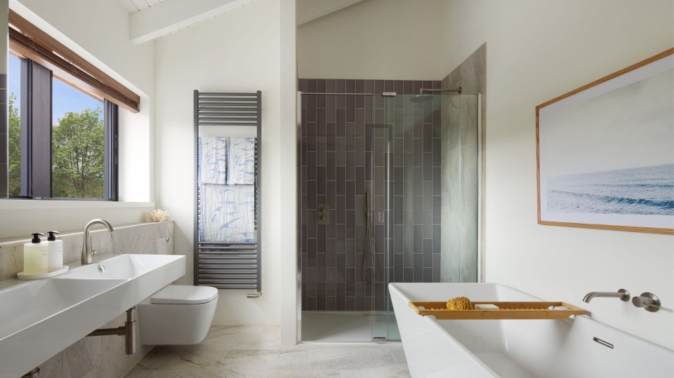 The bathroom has a large shower and a freestanding bathtub