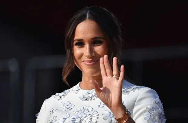 a woman in a white dress is waving her hand