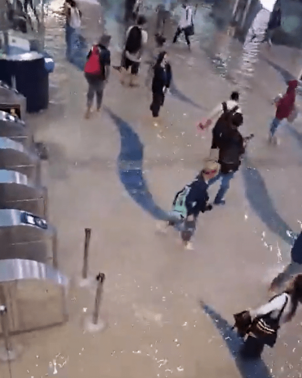 People have been forced to wade through horrendous floodwater at a metro station