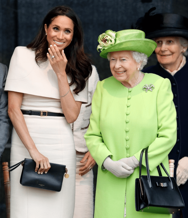 the queen is wearing a green coat and hat