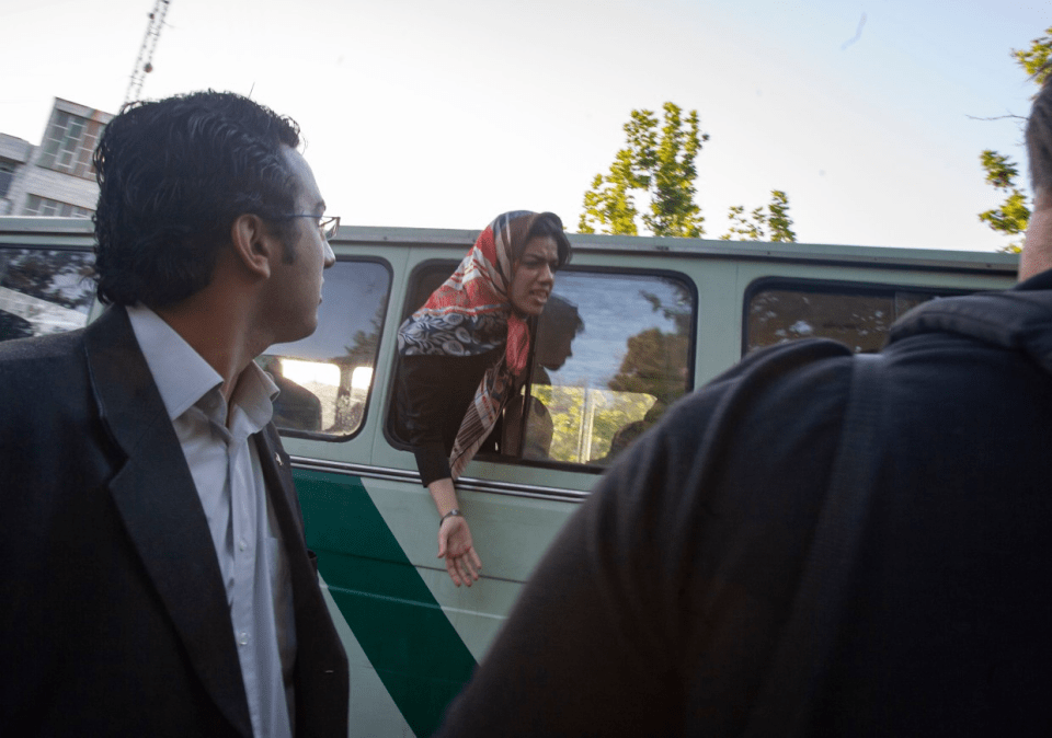 An Iranian woman shouts as she stands in a morality police van after being detained