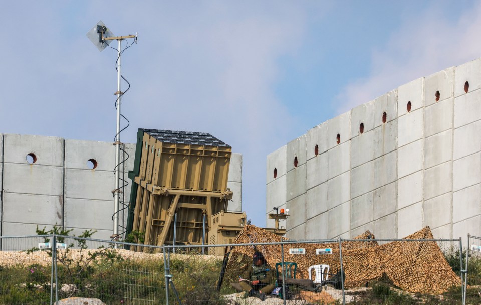 An Israeli soldier takes up a position in front of a battery of an Iron Dome air defence system near Jerusalem