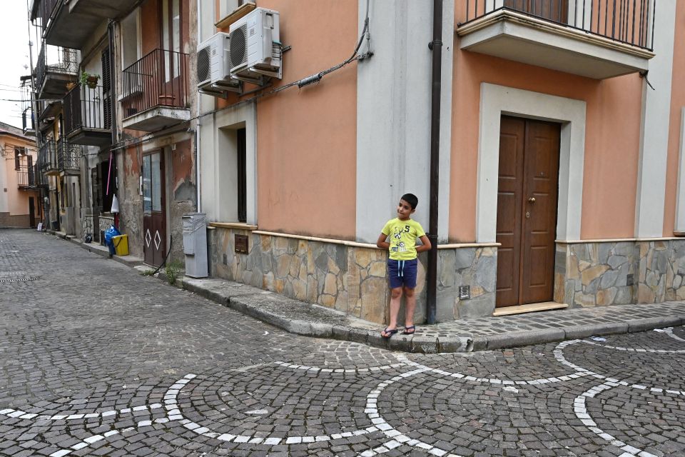 A child stands on a street of the old center in the town of Cinquefrondi in Calabria