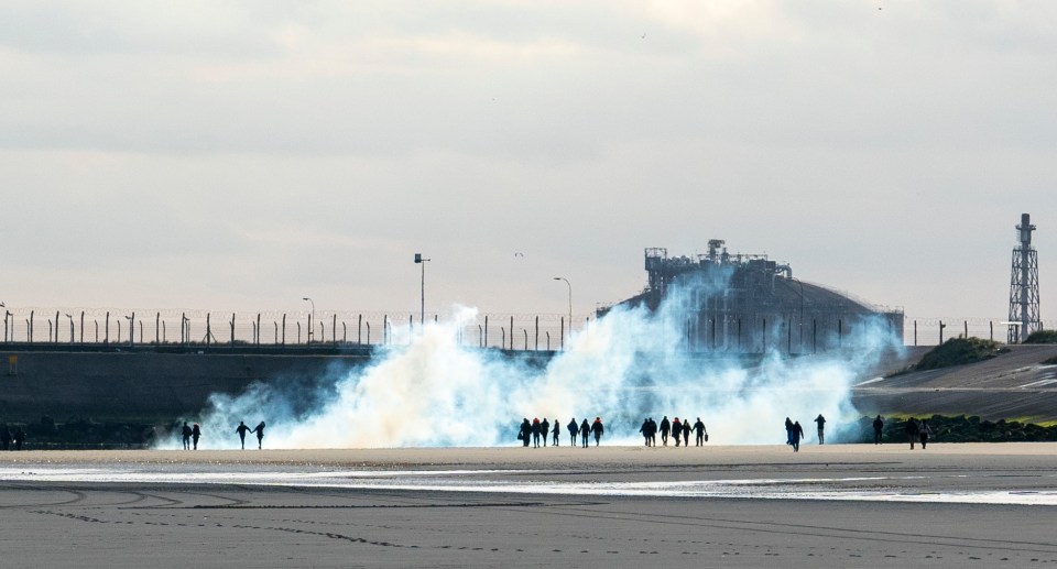 An army of migrants overpowered French cops to storm a beach and wade out to a 'taxi boat' service