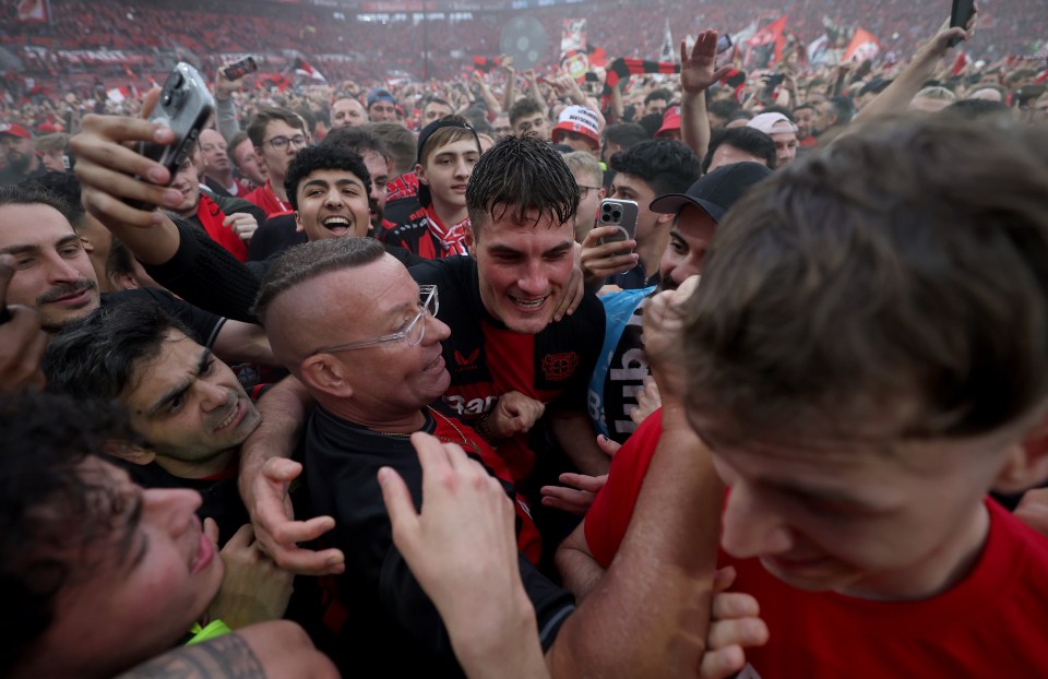 Leverkusen star Patrik Schick is engulfed by joyous supporters