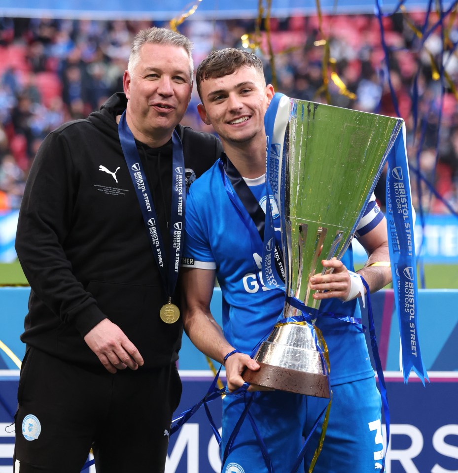 Harrison Burrows clutches the trophy alongside manager Darren Ferguson