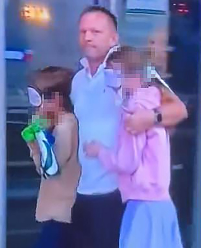 A dad was seen escorting his kids away from the scene of the horrific stabbing