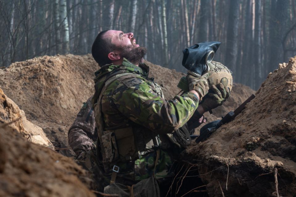 A Ukrainian troop taking off his gas mask after Russia has been accused of dropping tear gas attacks on the frontlines