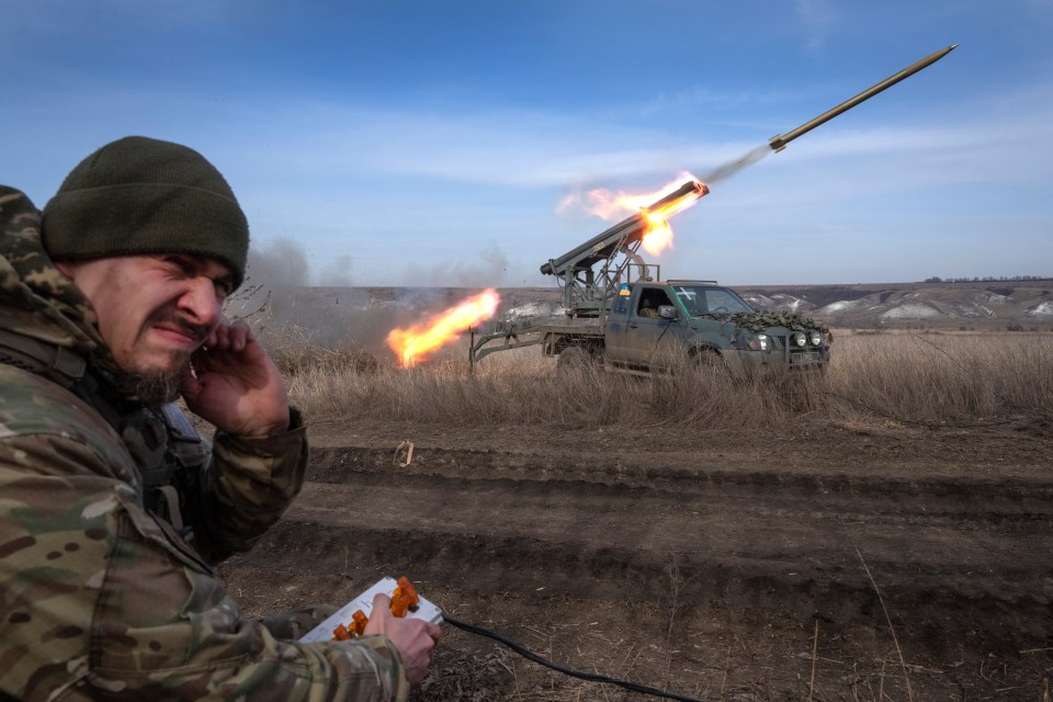 A Ukrainian officer with the 56th Separate Motorized Infantry Mariupol Brigade fires rockets from a pickup truck