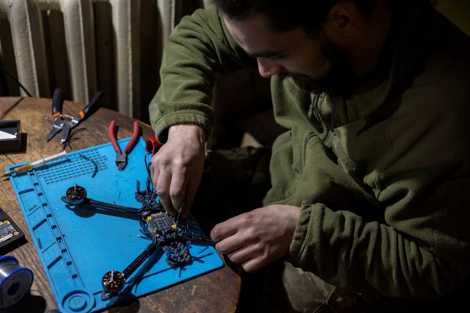 A specialist soldier is seen assembling a drone close to the frontline - but civilians are now helping to construct the UAVs from home