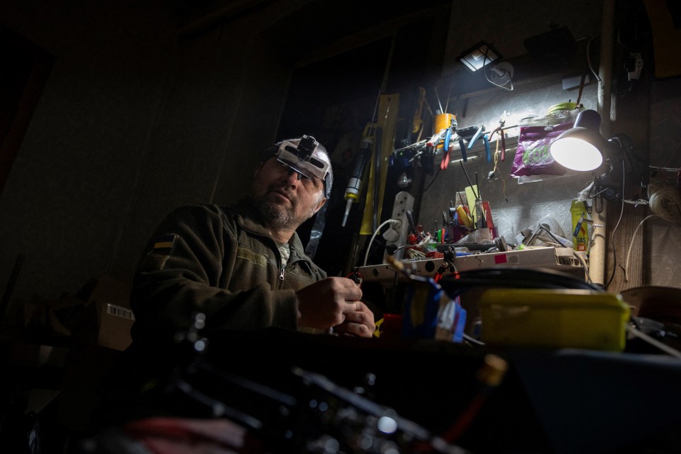 A troop in his workshop fixing FPV drones at night